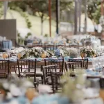 an outdoor all-inclusive wedding venue with dining table set pieces, dishes, and decor