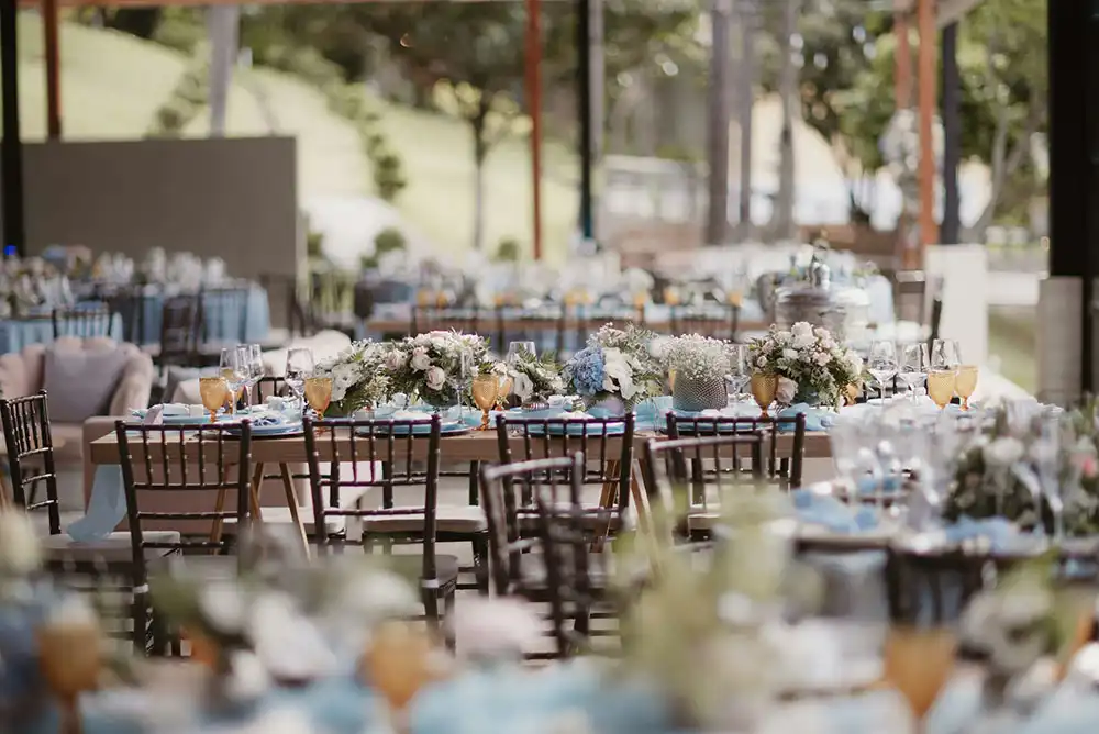 an outdoor all-inclusive wedding venue with dining table set pieces, dishes, and decor