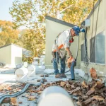 a commercial roofing contractor blowing leaves off a commercial roof